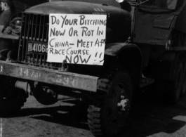 American truck with a sign advertising meeting at race course in the CBI during WWII.