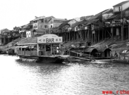 The bar barge and stilted houses at Liuzhou. Looking toward the other side of Liuzhou from the boat bridge, Sept. 1944.   From the collection of Frank Bates.