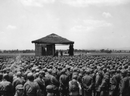 Chinese soldiers standing around a stage during a ceremony in southern China, probably Yunnan province, or possibly in Burma.