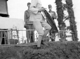 Chinese soldier of the 48th Army Division (陆军第四十八师) gets banner in a ceremony as part of a shooting contest ("射击比赛")  during a rally.