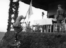 Chinese soldier climbs onto stage with banner during exercises in southern China, probably Yunnan province, or possibly in Burma.