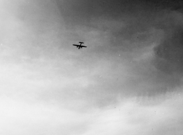 A B-25 Mitchell bomber high in flight in the CBI, in the area of southern China, Indochina, or Burma, during WWII.