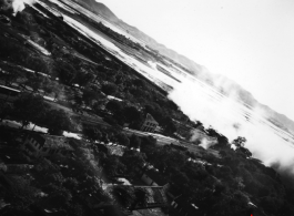 A railroad bridge is bombed on a river, probably in SW China, Indochina, or the China-Burma border region.