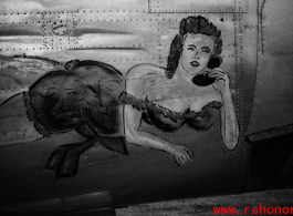 Nose art on a Consolidated B-24 bomber, of a buxom woman on the telephone. During WWII in China.