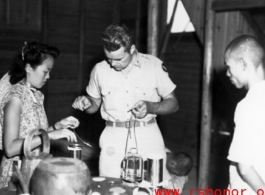 Americans and Chinese work together to provide medical treatment during WWII in China.  Note the sick Chinese man on the floor.