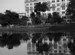 Large building and waterway in city.  Scenes in India witnessed by American GIs during WWII. For many Americans of that era, with their limited experience traveling, the everyday sights and sounds overseas were new, intriguing, and photo worthy.