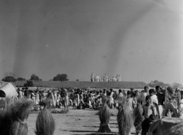 Busy market area with the roof of a temple beyond.  Scenes in India witnessed by American GIs during WWII. For many Americans of that era, with their limited experience traveling, the everyday sights and sounds overseas were new, intriguing, and photo worthy.