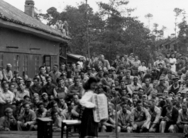 Celebrities (including here apparently Ruth Dennis) perform on an outdoor stage set up at the "Last Resort" at Yangkai, Yunnan province, during WWII. Notice both Americans and Chinese in the audience for this USO event.