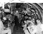 GIs and flight nurse (probably) on a transport plane. In the CBI during WWII.