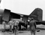 Unloading or loading supplies from C-47 transport plane in China during WWII.