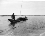 Local people in Yunnan province, China, on a small boat, collecting water grass. During WWII.  From the collection of Eugene T. Wozniak.