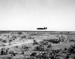 An American B-25D bomber flies at minimum altitude, probably during training / practice of 'low-level attack techniques.' Note the triangular peak just in front of the aircraft. This is probably piled up dirt and sand bags, used as the 'target' to learn and practice, especially for 'skip bombing'.   B-25 pilots of the Tenth Air Force (341st Bomb Group) and Chinese-American Composite Wing (1st Bomb Group) were trained in 'skip bombing' in India during 1943 and 1944.