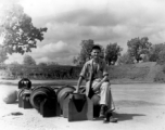 An American at a base in China sitting on bomb tail fins.  (Image from the collection of Eugene Wozniak)