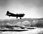 A C-46 lands in Yunnan province, flying in over the carcass of another C-46.