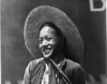 Local people in China: A smiling man stands in front of a large fuel tank.  From the collection of Eugene T. Wozniak.