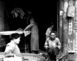 A small shop with local people and  in China, including a cobbler and tailor.  From the collection of Eugene T. Wozniak.