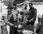 GIs buy citrus from farmers in China during WWII. These might be the amazing regional penggan (椪柑), somewhat similar to a mandarin orange.  Americans and Chinese interact at the market, China.  From the collection of Wozniak, combat photographer for the 491st Bomb Squadron, in the CBI.