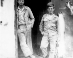 "Elmer Bukey and Chester Rush in the doorway of our engineering office at Liangshan,China. The holes and the damage seen are the results of nightly air raids by the Japanese. Our engineering area left a lot to be desired but it was amazing the amount of and the quality of the work that was performed by the men."