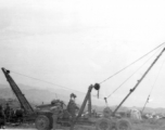 "This rig was dreamed up and built by Sgt.Miller and Sgt.Blumer. The 396th needed something that could handle all the heavy objects that had to be moved in the process of salvaging and repairing the aircraft we worked on. They built this rig on a 6x6 chasis and there wasn't much that it couldn't handle. They received a lot of praise for the job they did." Caption courtesy of Elmer Bukey.