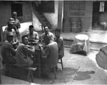 Chinese soldiers take a meal during WWII in the courtyard of a home, in Yunnan province, China, most likely around the Luliang air base area.