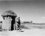 An American C-47 takes off behind a Chinese base guard in SW China during WWII.