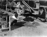 Chinese refugee waits with a bucket for hot water to drip from a steam train engine at the train station in Liuzhou during WWII, in the fall of 1944, as the Japanese advanced during the Ichigo campaign.