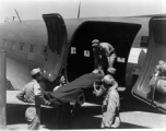 A GI is lifted on a stretcher into a C-47 for transport for medical care in the CBI during WWII.