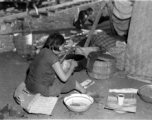 In the midst of calamity, a refugee mother tenderly washes her baby next to the train at the Liuzhou railway station in the fall of 1944.