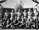 Men from the 21st Photographic Reconnaissance Squadron pose for a group shot in front of an F-5 (a variant of the P-38).