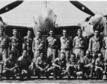 Men from the 21st Photographic Reconnaissance Squadron pose for a group shot in front of an F-5 (a variant of the P-38).