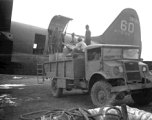 A C-46 transport plane (tail number #478199) being unloaded of fuel barrels by Chinese laborers at the air base at Luliang. During WWII.