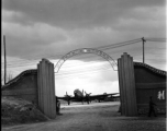 Guarded gates of the Nationalist Kunming Air Force Officer Training School during WWII, with C-46 transports.