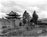 A city wall with gate (probably at Chengkung/Chenggong) and local people in Yunnan province, China.