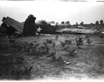 Wrecked B-25 Mitchell bomber on the ground in the CBI. The wreck was apparently at an air base, and probably on take-off, as the craft is sprayed with fire-retardant foam, and bombs are scattered about the wreck site. During WWII.