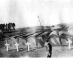 GI walks in front of vaults at an American military graveyard at Kunming, during WWII.