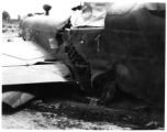 Wrecked B-25 Mitchell bomber on the ground in the CBI. The wreck was apparently at an air base, and probably on take-off, as the craft is sprayed with fire-retardant foam, and bombs are scattered about the wreck site. During WWII.