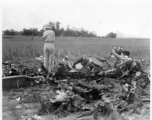 GIs look over devastating crash site of an American aircraft--the bent .50 cal machine gun in one image indicates it is American, and the gun mounting is like that of the nose gun of some B-25 Mitchells.  In this image set, the intensity by which people are searching the crash site, and the solemn nature of it all, makes one wonder if they are not looking for human remains.