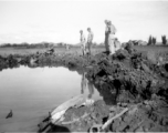 GIs look over devastating crash site of an American aircraft--the bent .50 cal machine gun in one image indicates it is American, and the gun mounting is like that of the nose gun of some B-25 Mitchells.  In this image set, the intensity by which people are searching the crash site, and the solemn nature of it all, makes one wonder if they are not looking for human remains.