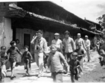 People walk on road at Yangkai village, including  a GI carrying a camera. During WWII.