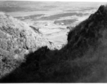 An American serviceman (partially hidden in shadow) walking on the hill above Yangkai air base, in Yunnan province, China, during WWII. He is being escorted by a local boy.