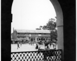 View out through archway to street and shops.  Scenes in India witnessed by American GIs during WWII. For many Americans of that era, with their limited experience traveling, the everyday sights and sounds overseas were new, intriguing, and photo worthy.