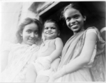 Older sisters hold pride and joy brother.  Scenes in India witnessed by American GIs during WWII. For many Americans of that era, with their limited experience traveling, the everyday sights and sounds overseas were new, intriguing, and photo worthy.