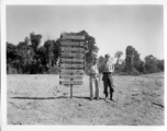 GIs pose before road sign on Burma Road.  797th Engineer Forestry Company.  During WWII.