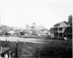 Fence village in Burma. A small crude stage is built in front of the house on the far right.  Near the 797th Engineer Forestry Company.  During WWII.