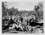 Engineers of the 797th Engineer Forestry Company pose outside on pile of sawn lumber at a camp in Burma.  During WWII.