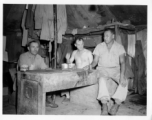 Engineers of the 797th Engineer Forestry Company pose in their tent in Burma, with checker pieces.  During WWII.