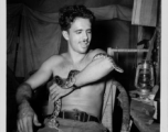 Engineer of the 797th Engineer Forestry Company poses with snake in tent in Burma.  During WWII.