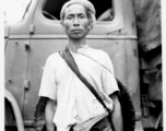 Local people in Burma near the 797th Engineer Forestry Company--A man poses in front of GI truck.  During WWII.