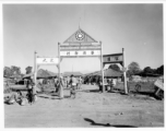 A Chinese settlement in Burma, with Nationalist insignia on gate archway. This is likely to be a settlement highly reliant on trade and commerce as its niche.  Near the 797th Engineer Forestry Company.  During WWII.  "华侨新村“  “祖国之光”