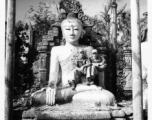 GIs sit on Buddha statue in remains of Buddhist temple in Burma.  During WWII.